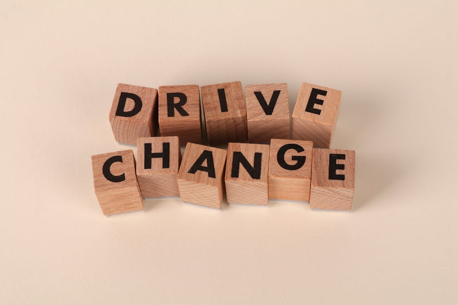 中立的な背景に「Drive Change」と書かれた木製のブロック。モチベーションと成長を象徴しています。