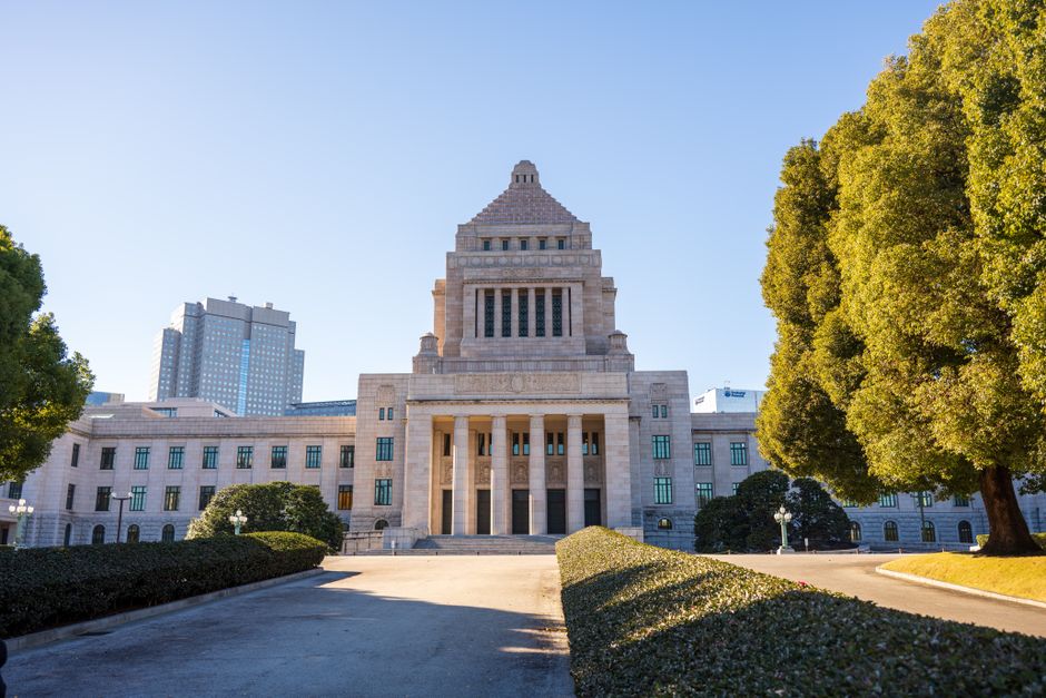 晴れた日の東京の国会議事堂の正面図。古典的な建築様式が目を引きます。