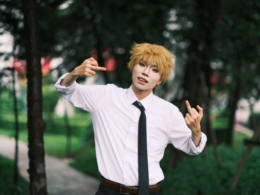 コスプレイヤーが公園でエネルギッシュにポーズをとり、表現力豊かなコスプレファッションを披露している。