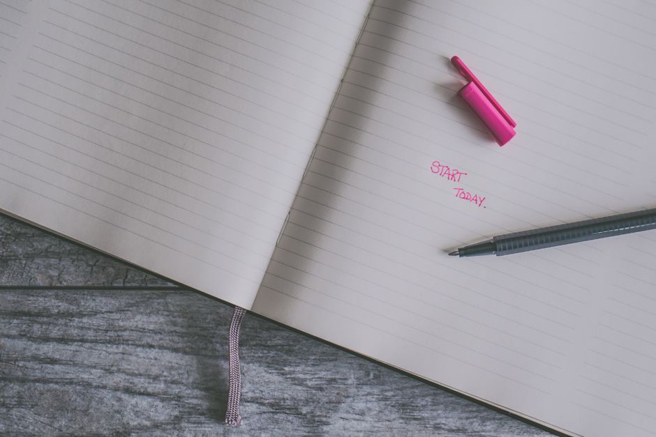 木の表面にあるピンクのハイライトとペンがある開いた罫線ノート、インスピレーションを与える書き込みテーマ。