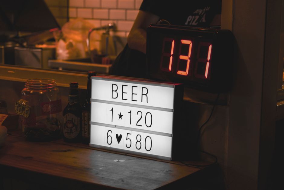 薄暗い環境でのビール価格のサインとデジタルライトの屋内シーン。