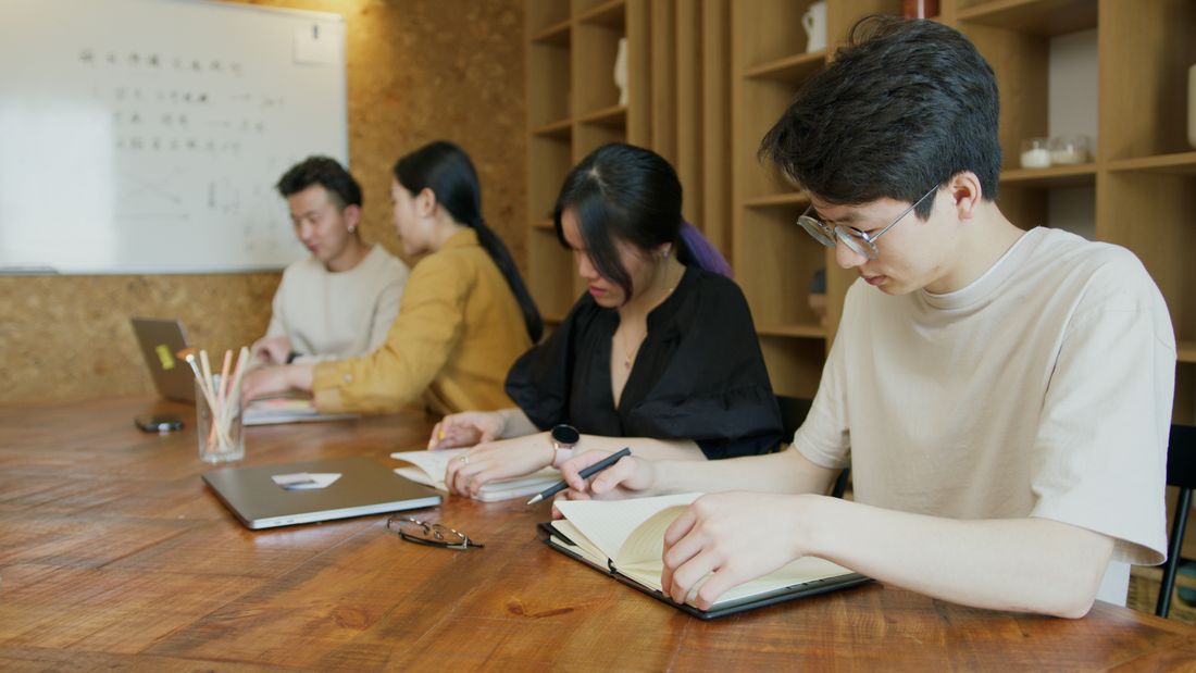 学業と両立する学生店長の働き方をイメージさせる教室で学ぶ大学生